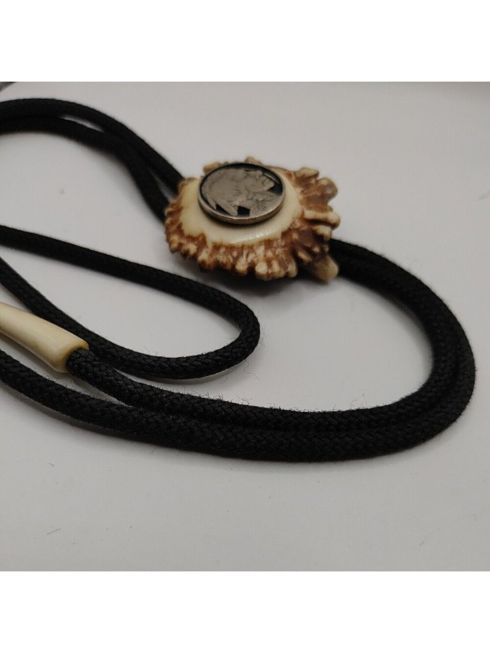 Bolo Tie 1936 Nickel In Resin / Resin Tip Ends / Cloth Braided Tie